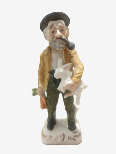 Vintage Ucago Japan ceramic farmer figurine holding a white rabbit and carrot with pipe and hand-painted details.