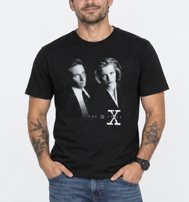 Male model wearing black X Files T-shirt with blue jeans on a light studio background