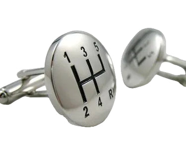 A pair of silver metal cufflinks with a gear shift design on a white background.
