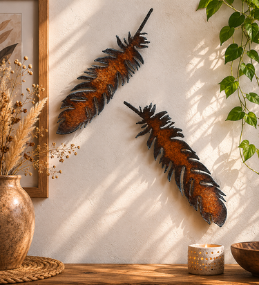 Pair of rustic steel feather wall décor pieces with weathered industrial finish displayed together.