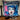 Decorative pillow with a graphic design of a woman's face and 'Anarchy!' text, placed on a surface with candles and a necklace.  Planet Retro NZ.