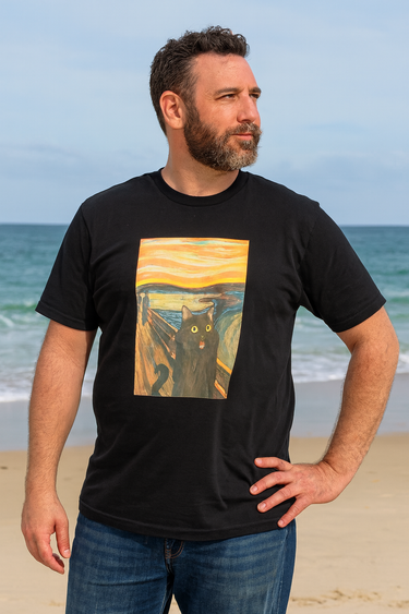Man wearing a black t-shirt with a cat painting on a beach