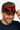 Man wearing a black and red cap with a unique design, smiling against a neutral background