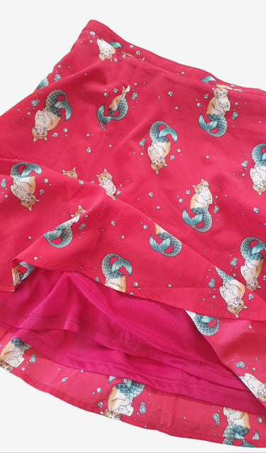 Red fabric with mermaid pattern on a beige background
