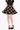 Person wearing a black skirt with a pattern of small animals on a white background
