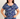 Woman wearing a blue floral patterned shirt against a plain background