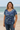 Woman wearing a blue floral shirt on a beach
