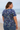 Woman wearing a blue floral top on a beach