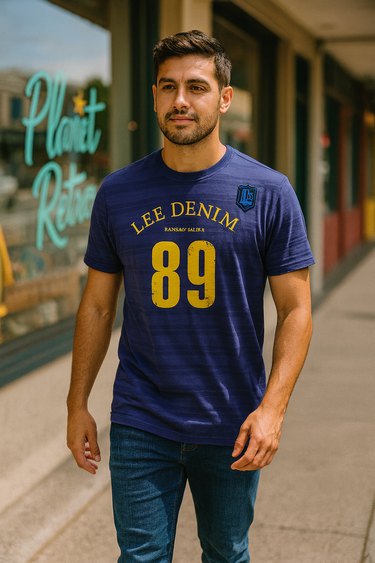 Man wearing a blue Lee Denim t-shirt with yellow text standing on a sidewalk.