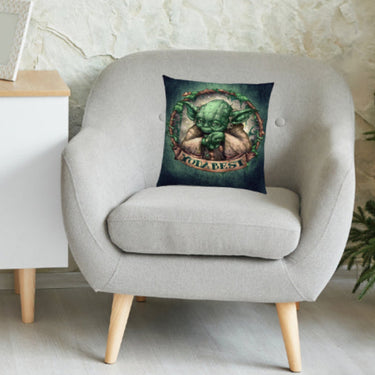 Gray armchair with a decorative pillow featuring a Yoda from Star Wars design against a white wall.