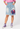 Model wearing Planet Retro Stranger Things Vecna upcycled denim button skirt with pink shirt and purple high-top trainers – AI styled image