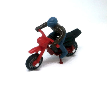 Toy figure of a person on a red motorcycle against a white background
