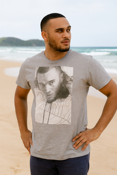 Man wearing a gray t-shirt with a graphic design on a beach