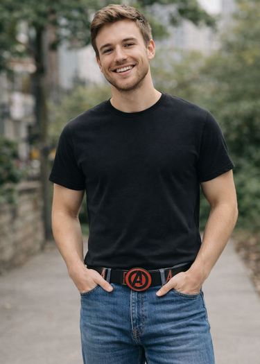 Man wearing a black t-shirt and blue jeans with a belt featuring a circular design outdoors.