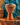 Carved wooden djembe drum displayed against a teal wall with dappled sunlight, woven baskets and African-inspired textiles