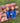 Pair of Chucky Naughty and Nice doll earrings with red hair, blue overalls and silver hooks on a light studio background
