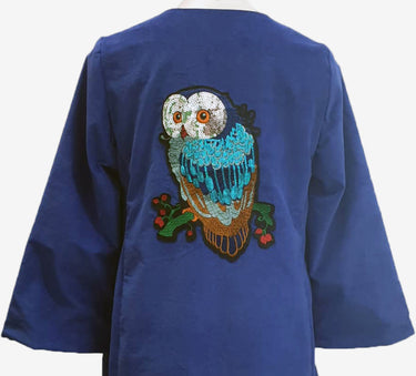 Blue dress with an owl design on the back against a white background