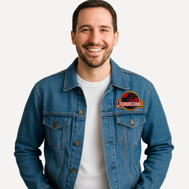 Man wearing a blue denim jacket with a Jurassic Park patch on a white background
