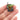 Yoda Grogu Harry Potter pin held between fingers on a white background