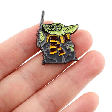 Yoda Grogu Harry Potter pin held between fingers on a white background