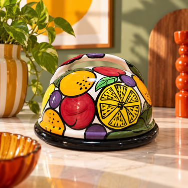 Hand painted fruit ceramic cheese dome and platter styled in a retro interior