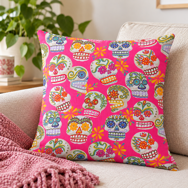 Hot Pink Sugar Skulls cushion cover styled on a cream sofa with a pink throw and greenery