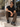 I Love Ugly brown checked men's pants size Large styled outdoors on seated male model wearing black sunglasses