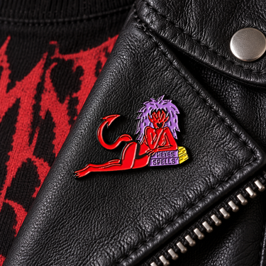 Killstar SheDevil red devil enamel pin with purple hair and Hexes Spells book on a black leather jacket lapel
