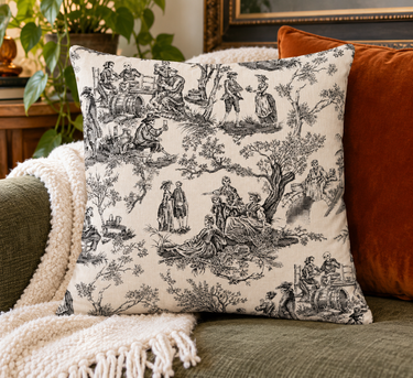 Lord and Lady Skullington black toile cushion cover styled on olive sofa with rust cushion and cream throw