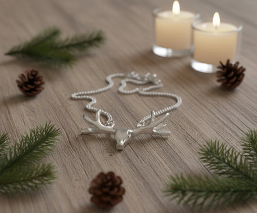 Silver deer head necklace on a white background