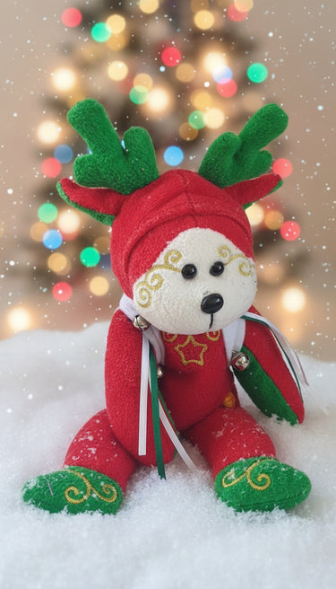 Decorative bear ornament with red coat, green hat and gloves on a white background