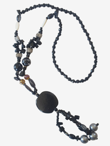 Black beaded necklace with a large central stone on a light background