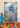 Colorful bird-like creature in ornate clothing with a mountain and forest background, displayed on an easel.  Planet retro nz