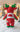 Red and green plush toy on a white surface