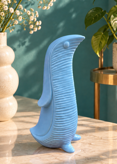 Sky blue modernist ceramic penguin styled in a teal interior