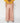 Person wearing a yellow top and floral wide-leg pants on a white background Planet Retro NZ