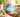 Unsigned blue and turquoise fat lava style studio pottery teapot displayed on a wooden board in a sunlit setting
