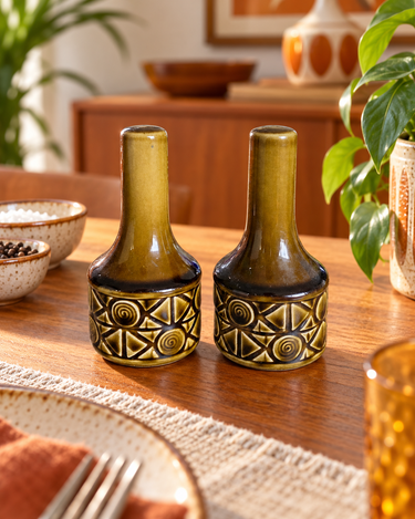 Vintage Beswick Zorba salt and pepper pair displayed on a warm wooden mid-century dining table