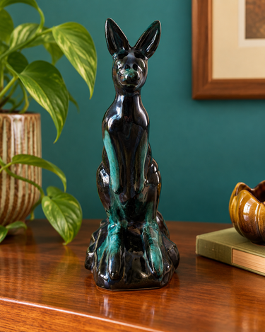 Vintage Blue Mountain Pottery kangaroo in glossy dark green glaze, styled against a teal wall