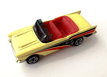 Yellow toy convertible car with red interior on a white background