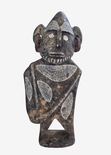 A carved stone bust sculpture of a stylized human figure with a horned headdress, standing on a base.