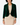 A woman modeling a dark green velvet cropped jacket over a beige dress, standing against a light gray studio background.
