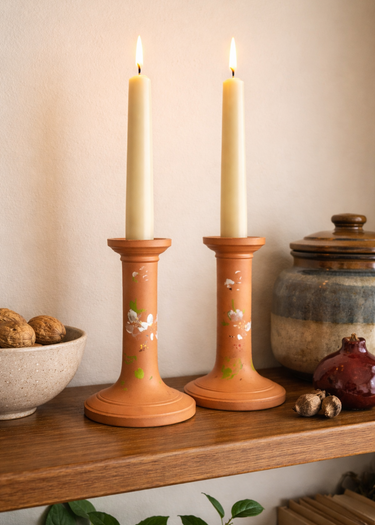 Pair of vintage Watcombe Torquay terracotta candlestick holders with hand-painted white floral design, 14cm tall.